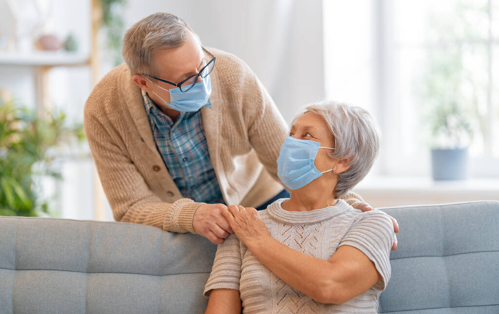 Älteres Paar trägt Gesichtsmasken während des Coronavirus und des Grippeausbruchs. Viren- und Krankheitsschutz, Quarantäne zu Hause. COVID-2019. Masken anziehen oder ablegen. - Foto, Bild