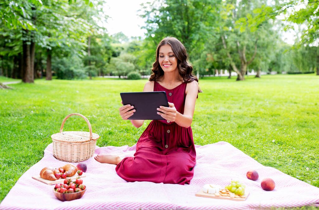 happy woman with tablet computer on picnic at park - Photo, Image
