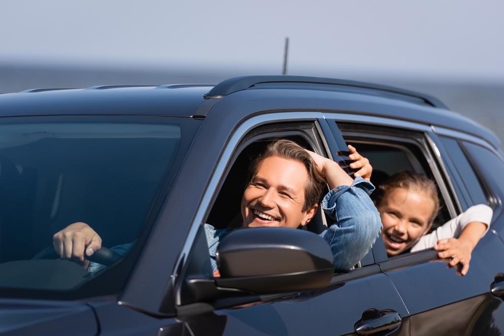 Selektywne skupienie ojca jazdy samochodem w pobliżu podekscytowanej córki  - Zdjęcie, obraz