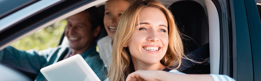 Koncepcja pozioma kobiety z tabletem cyfrowym odwracając wzrok podczas podróży z rodziną w samochodzie  - Zdjęcie, obraz