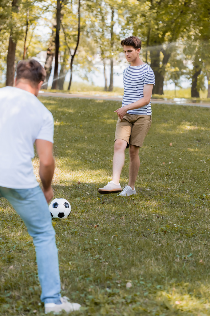 selective focus of teenager son playing football with father - Photo, Image