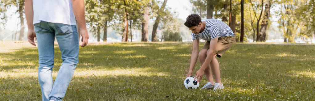 cosecha panorámica de adolescente jugando al fútbol con el padre - Foto, Imagen