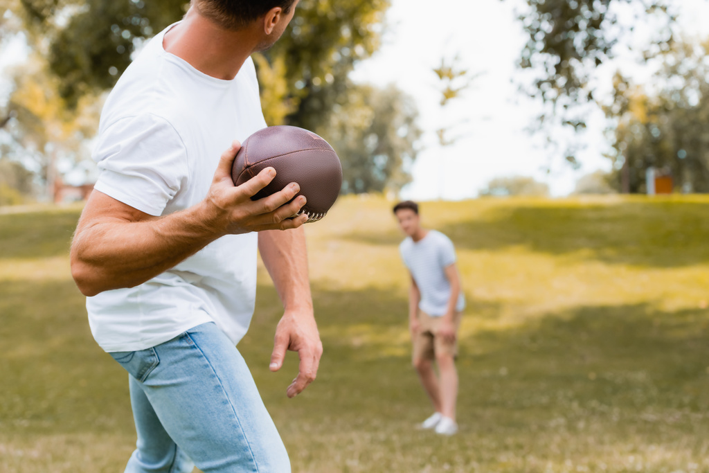 selektivní zaměření muže házení rugby míč na syna v parku  - Fotografie, Obrázek