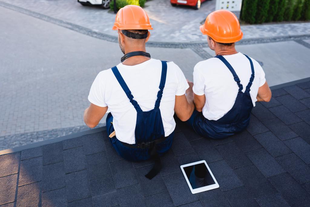 Taustakuva rakentajille istuu lähellä digitaalinen tabletti katolla rakennuksen  - Valokuva, kuva