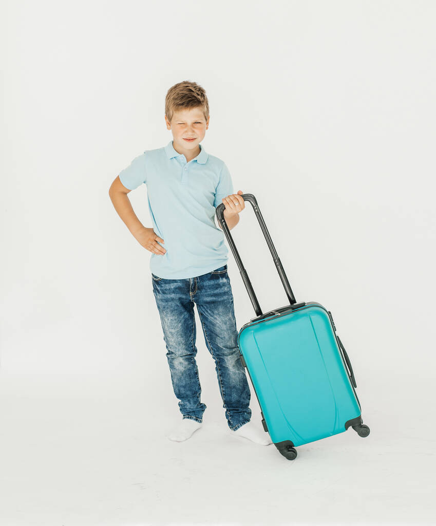 De jonge reiziger met een koffer. Geïsoleerd over witte achtergrond - Foto, afbeelding