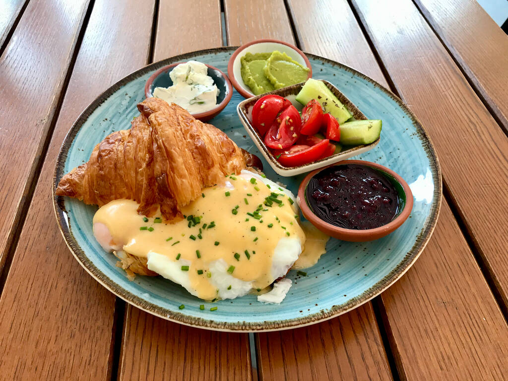Tabliczka śniadaniowa z gotowanym jajkiem w rogaliku Benedict i sosem Hollandaise w Cafe Restaurant. Gotowy służyć i jeść. - Zdjęcie, obraz