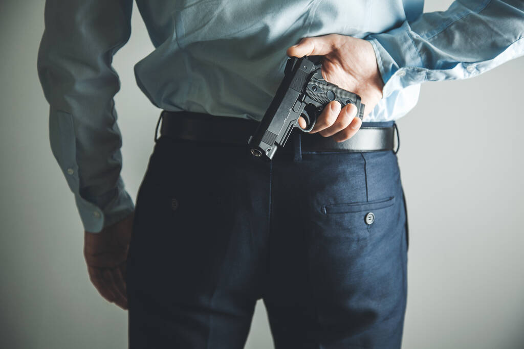 man hand gun in back - Фото, изображение