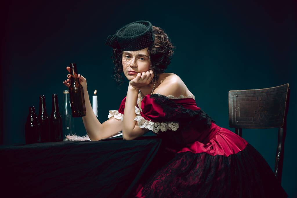 Young woman as Anna Karenina on dark blue background. Retro style, comparison of eras concept. - Photo, Image