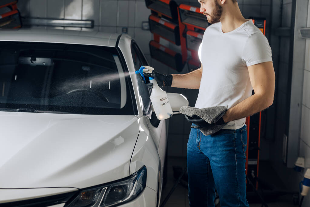 trabalhador atraente limpeza carro pára-brisas na garagem - Foto, Imagem