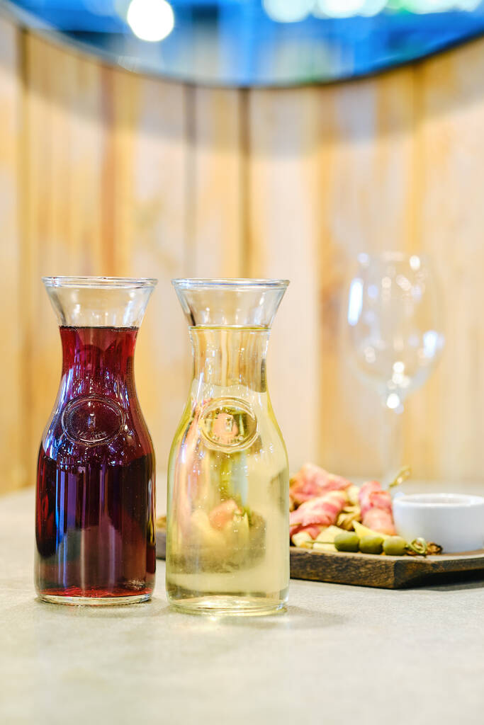Két decanters bor és lemez snack a háttérben (lágy fókusz fotó sekély mélysége mező) - Fotó, kép