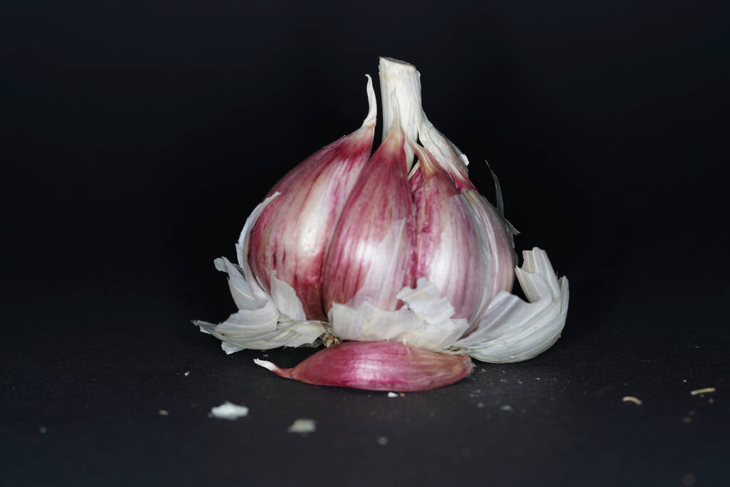 A closeup shot of fresh garlic on a black background - Photo, Image