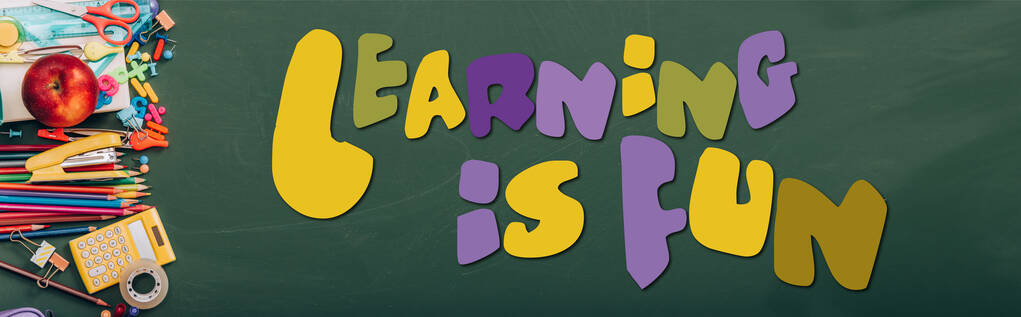 colpo panoramico di mela matura, calcolatrice e cancelleria scolastica su lavagna verde con apprendimento è divertente lettering  - Foto, immagini