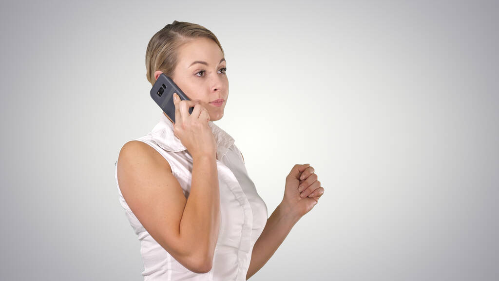 Charmante zakenvrouw bellen met mobiele telefoon terwijl staan op gradiënt achtergrond. - Foto, afbeelding