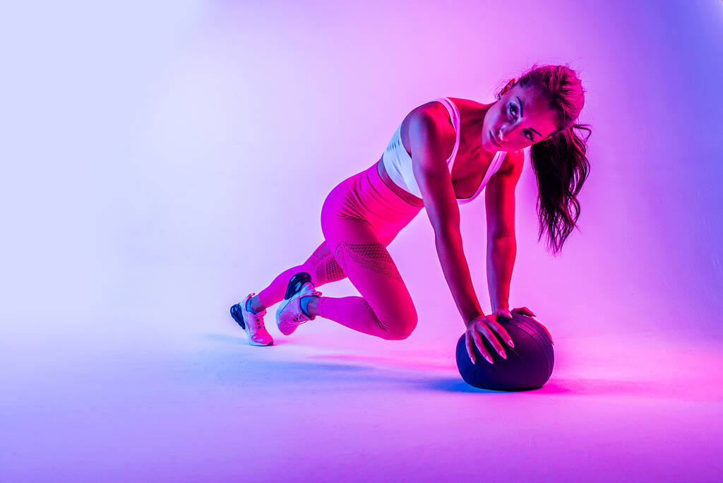 atletische vrouw met fitness sportkleding traning - mooi meisje doet fitness in een studio - Foto, afbeelding