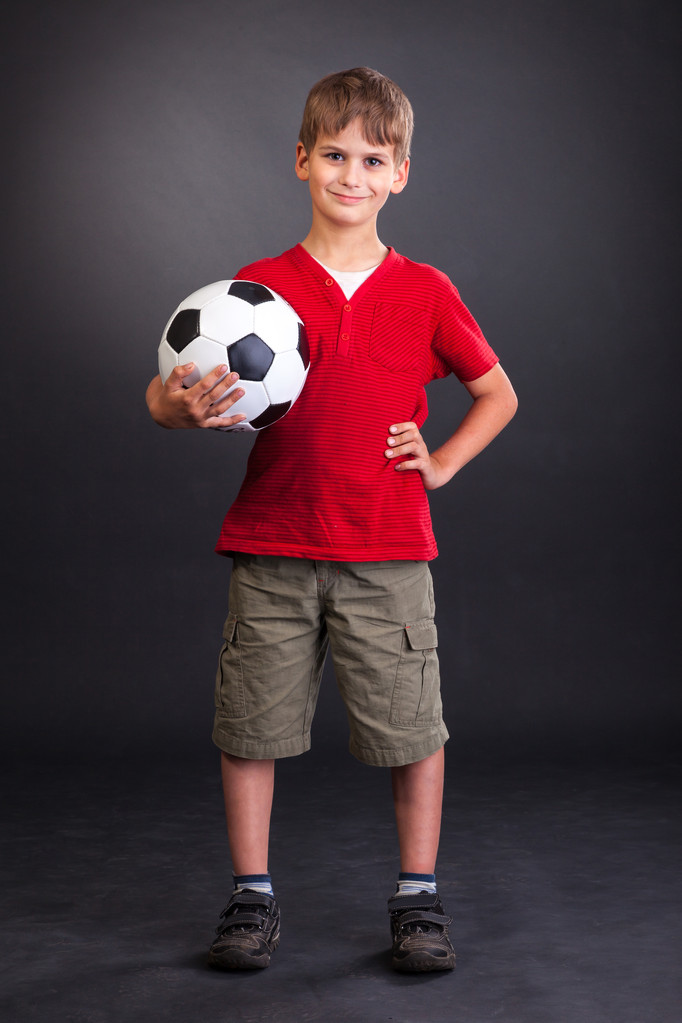 Boy está sosteniendo una pelota de fútbol
 - Foto, imagen