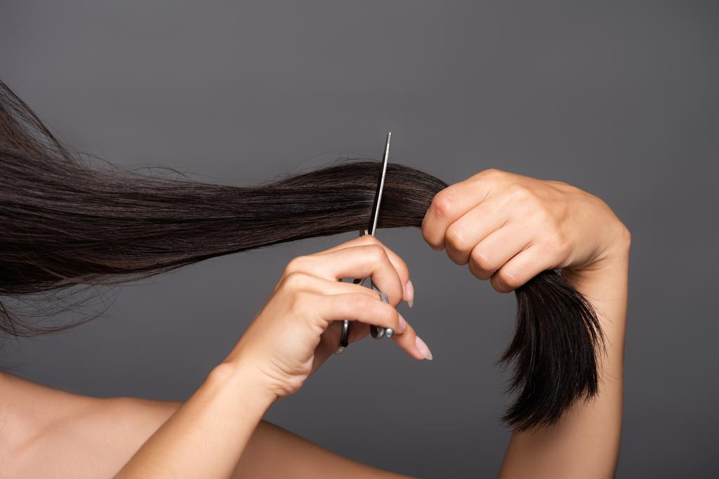 ostříhaný pohled na nahé brunetky žena stříhání vlasy izolované na černé - Fotografie, Obrázek