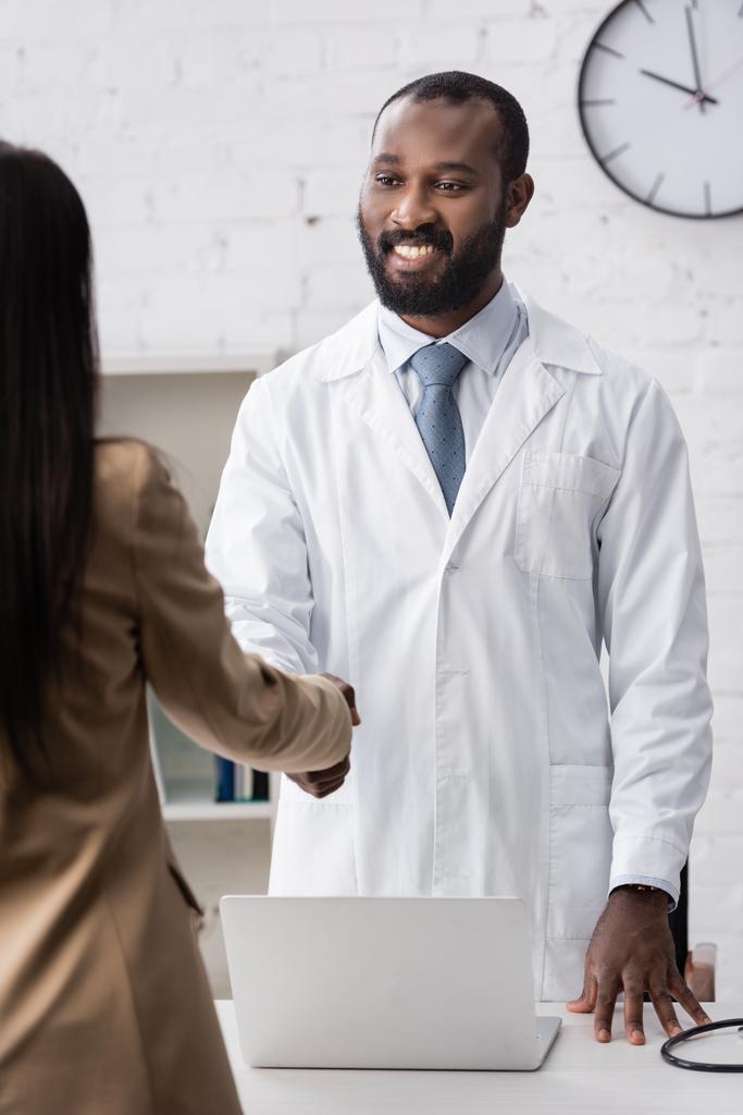 Valikoiva painopiste afrikkalainen amerikkalainen lääkäri seisoo ja katsot potilaan - Valokuva, kuva