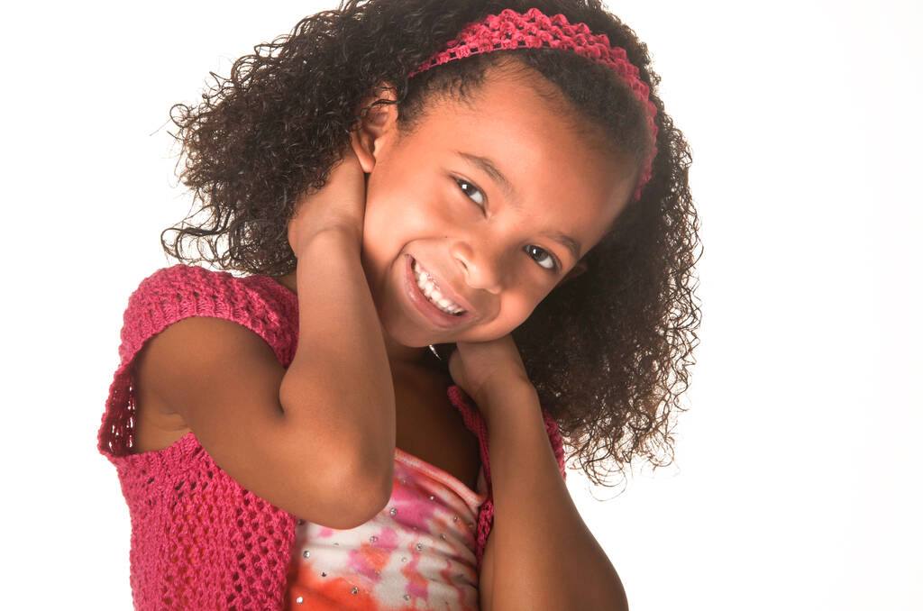 Усміхнена щаслива маленька дівчинка з красивим кучерявим волоссям
 - Фото, зображення