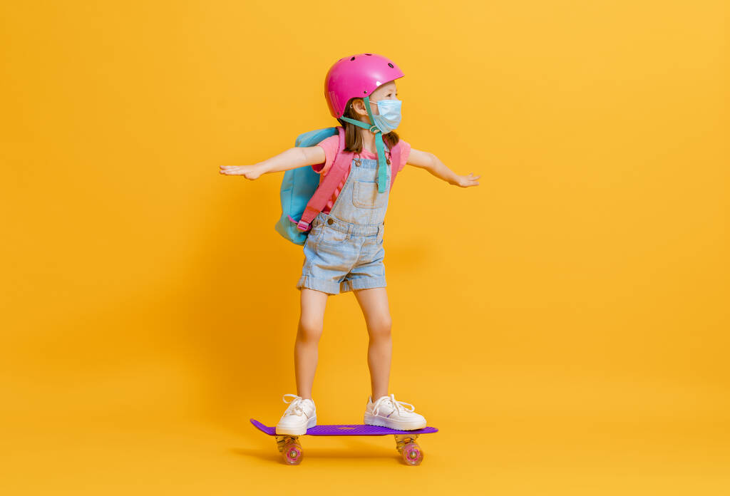 Дитинство і щасливий час! Симпатична дитина зі скейтбордом на кольоровому фоні паперу. Малюк з рюкзаком. Дівчина готова вчитися
. - Фото, зображення