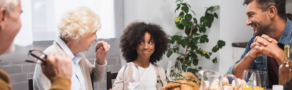 selectieve focus van vreugdevol Afrikaans Amerikaans meisje vieren Thanksgiving dag met familie, horizontaal beeld - Foto, afbeelding