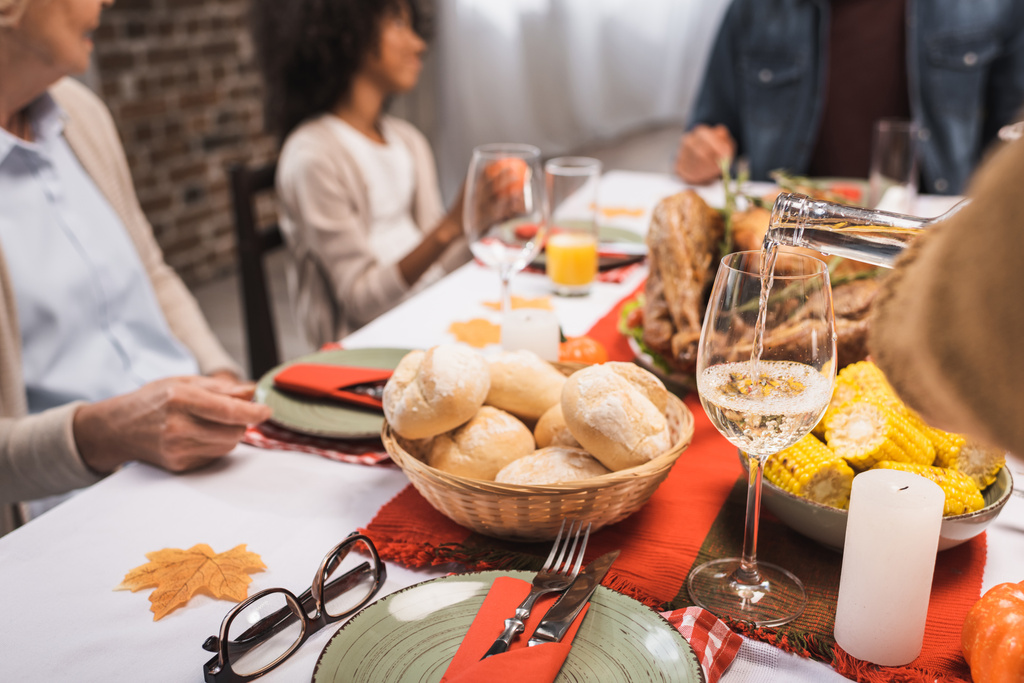 selektivní zaměření multikulturní rodiny slaví díkůvzdání u stolu podávané s lahodnou večeří - Fotografie, Obrázek