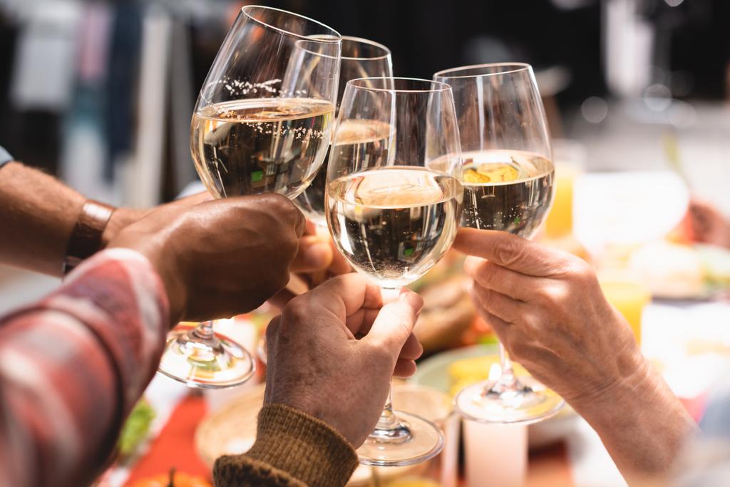 обрезанный вид мультикультурных родственников звон бокалов вина во время праздничного ужина - Фото, изображение