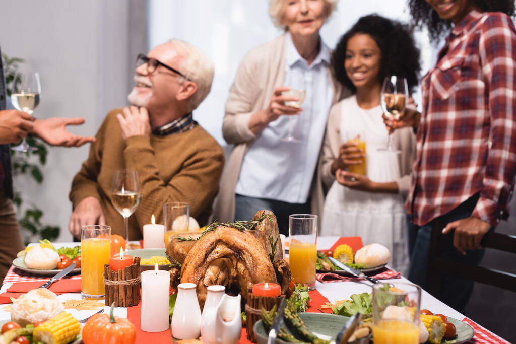 selective focus of multiethnic family celebrating thanksgiving at table with festive dinner - Photo, Image