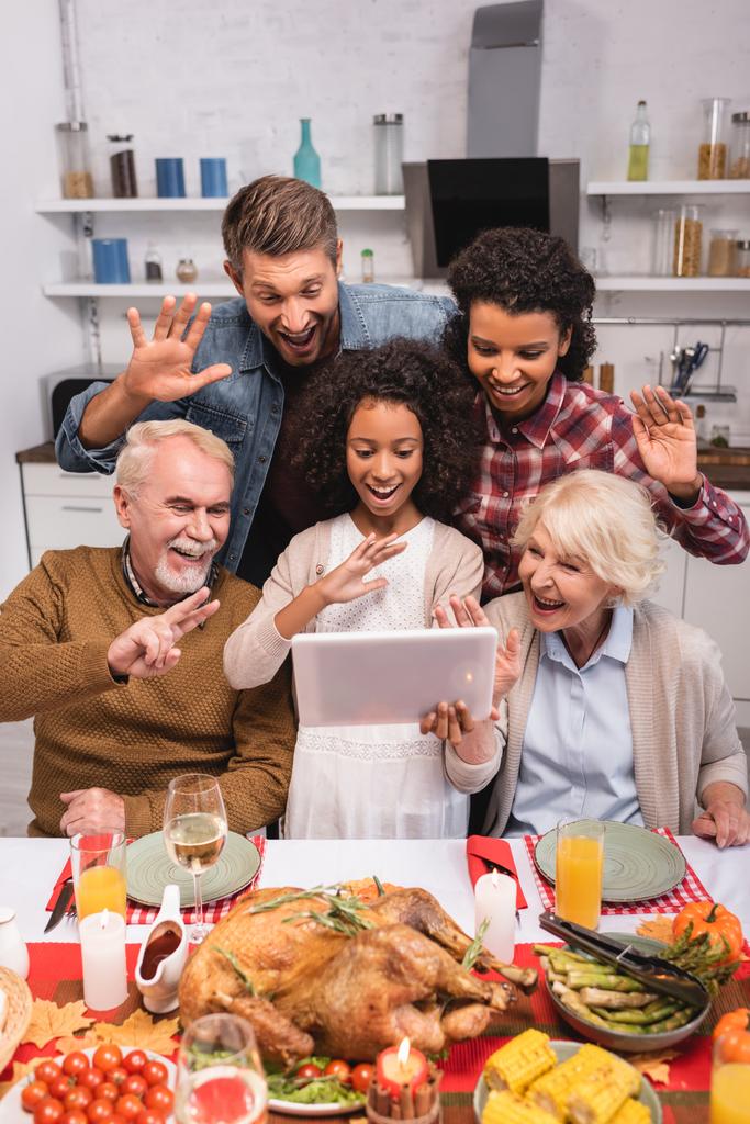 Enfoque selectivo del gesto familiar multicultural durante la videollamada en tabletas digitales y la celebración de Acción de Gracias  - Foto, imagen