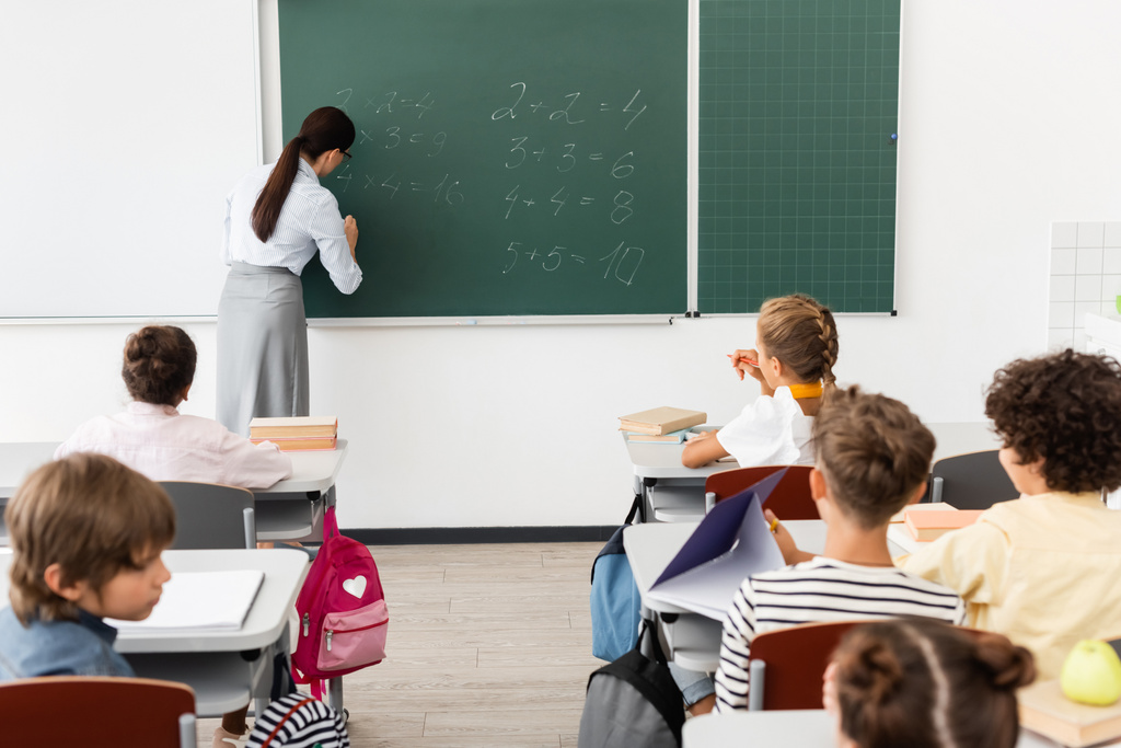 visszapillantás tanár írás egyenletek táblán közelében multikulturális tanulók matek óra alatt - Fotó, kép