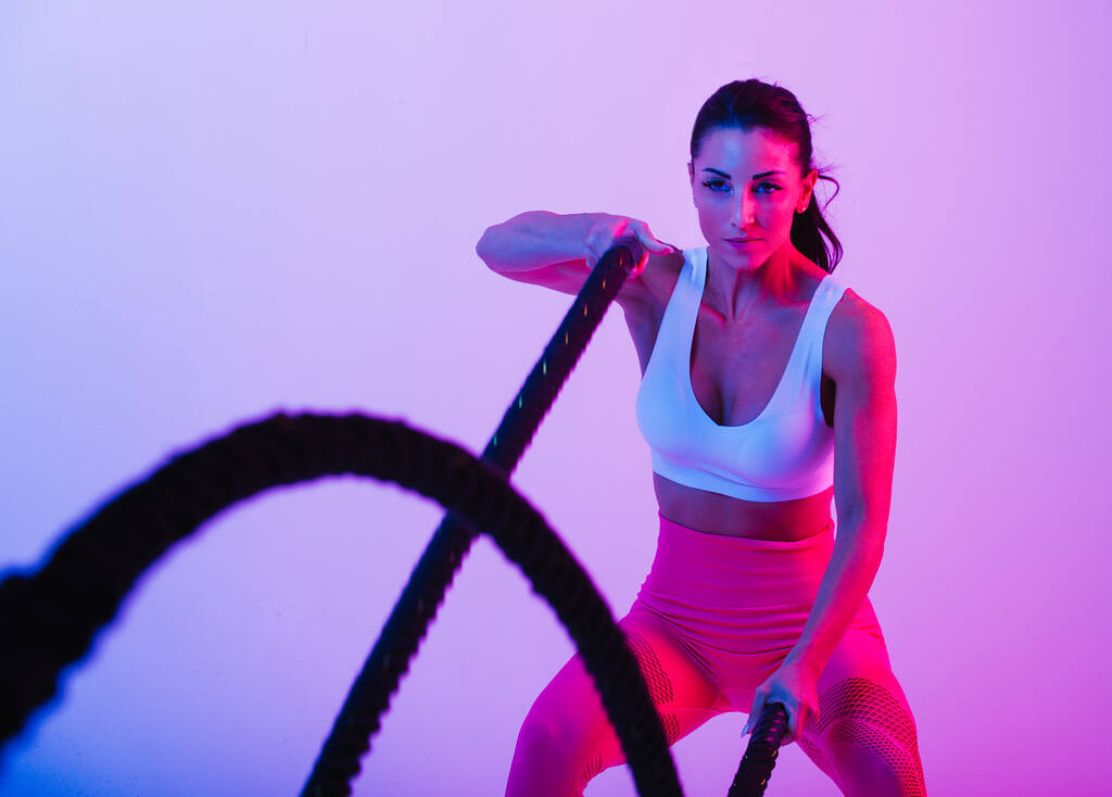 Femme athlétique avec des vêtements de sport de fitness traning - Belle fille faisant du fitness dans un studio - Photo, image
