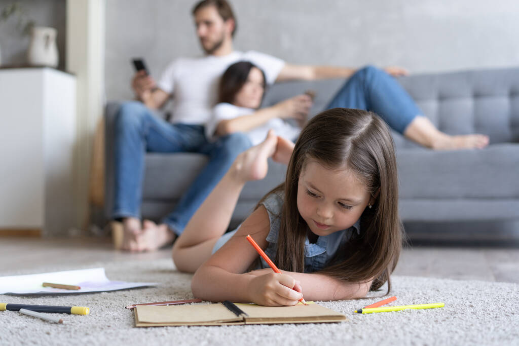 Χαριτωμένο κοριτσάκι παίζει στο πάτωμα, προνήπιο κοριτσάκι ζωγραφίζει με χρωματιστά μολύβια σε χαρτί περνώντας χρόνο με την οικογένεια - Φωτογραφία, εικόνα