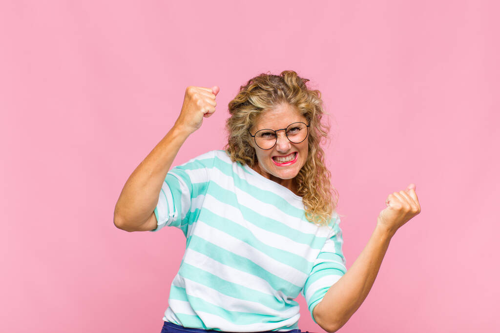 mujer de mediana edad sintiéndose feliz, positiva y exitosa, celebrando la victoria, logros o buena suerte - Foto, Imagen