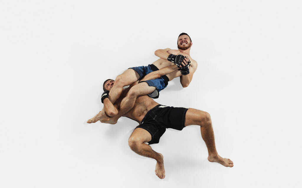 Два профессиональных боксера ММА изолированы на белом студийном фоне, динамичны и подвижны. Вид сверху - Фото, изображение
