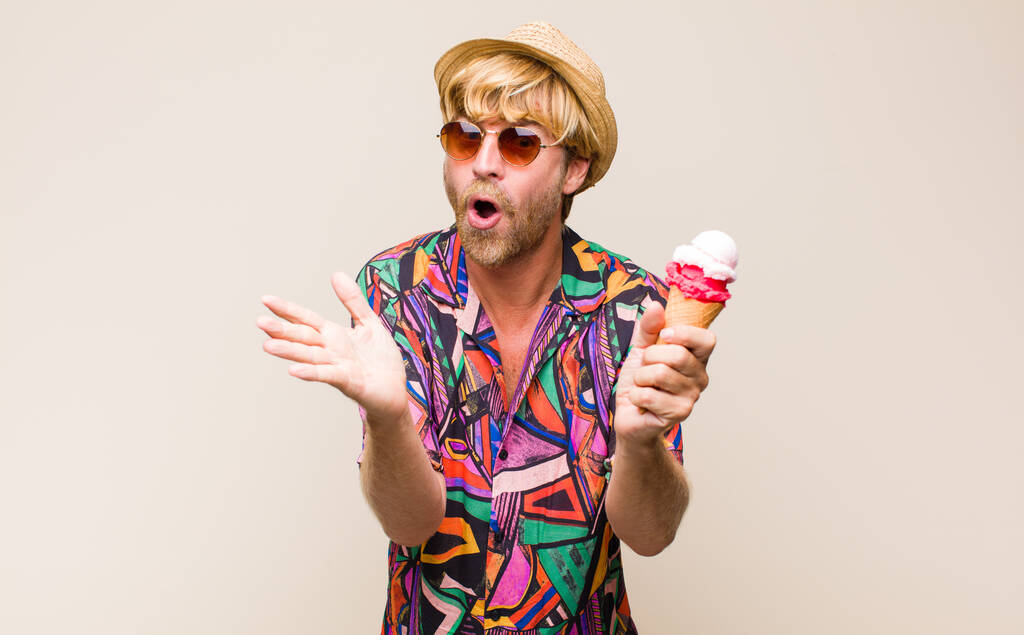 ξανθός ενήλικας που κρατάει παγωτό με καπέλο και γυαλιά ηλίου - Φωτογραφία, εικόνα