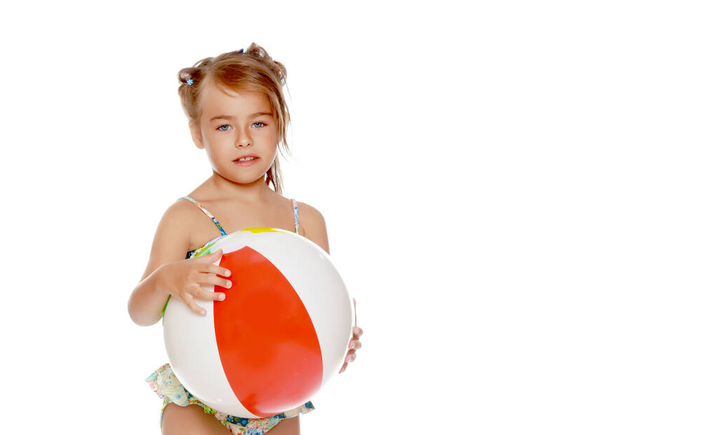 Mała dziewczynka w kostiumie kąpielowym z piłką. Koncepcja emocji dzieci. - Zdjęcie, obraz