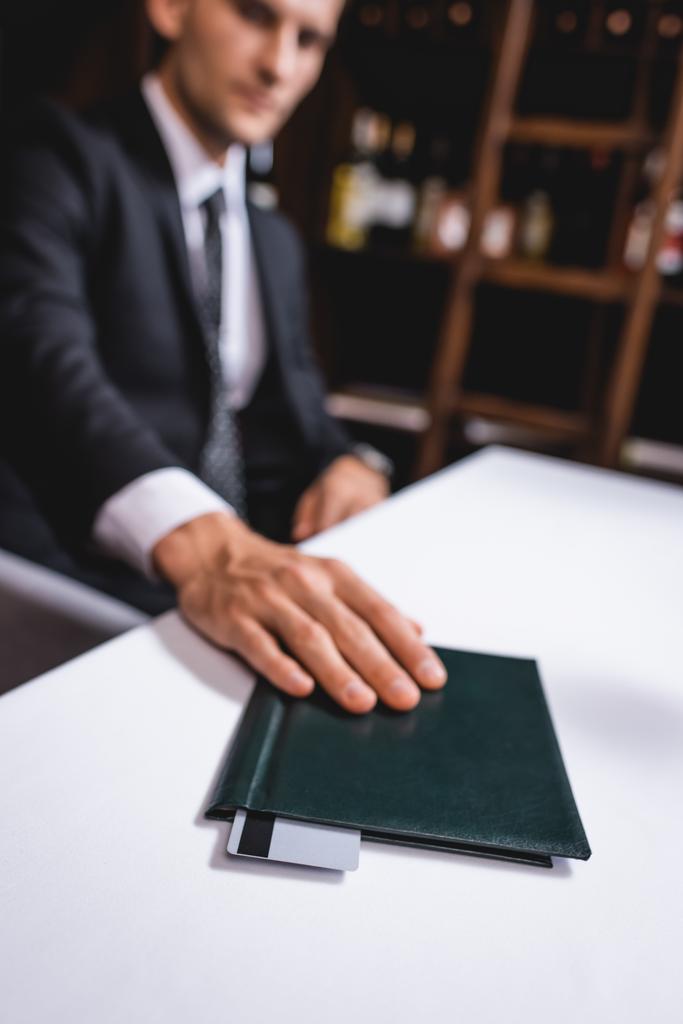 Вибірковий фокус людини в костюмі покласти рахунок ресторану з кредитною карткою на столі
  - Фото, зображення