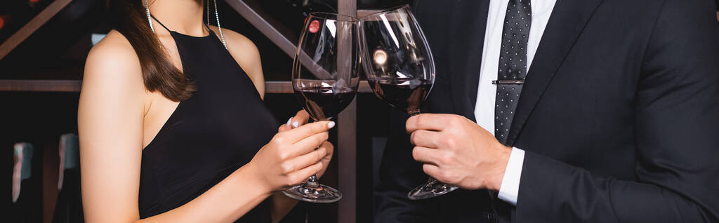 Панорамный урожай элегантной пары, звенящей с вином в ресторане  - Фото, изображение