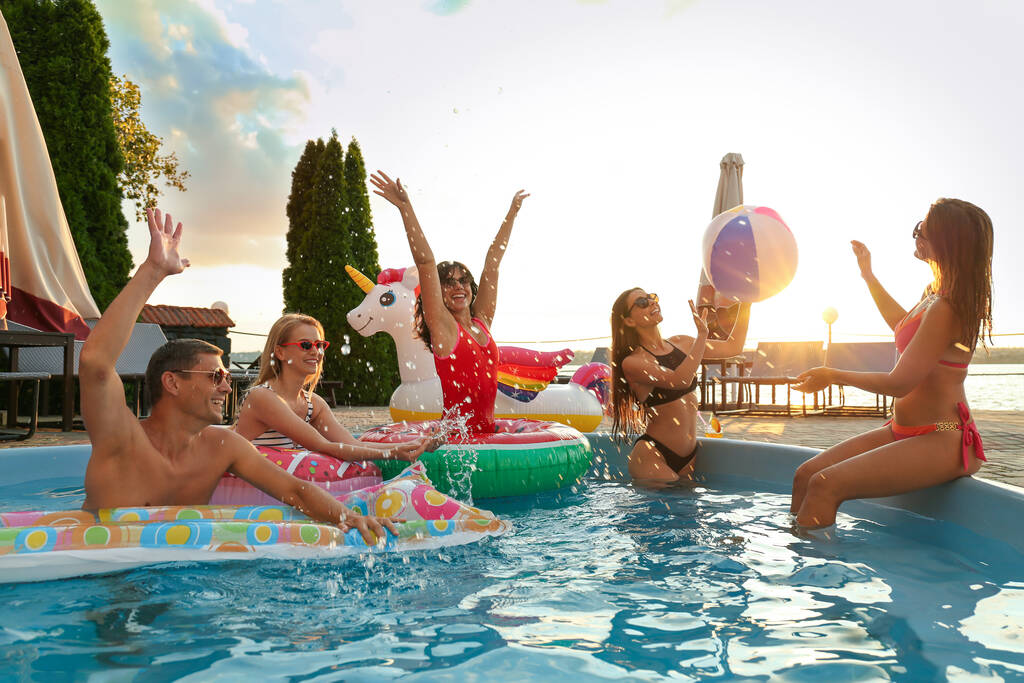 Grupo de personas felices disfrutando de una divertida fiesta en la piscina - Foto, imagen