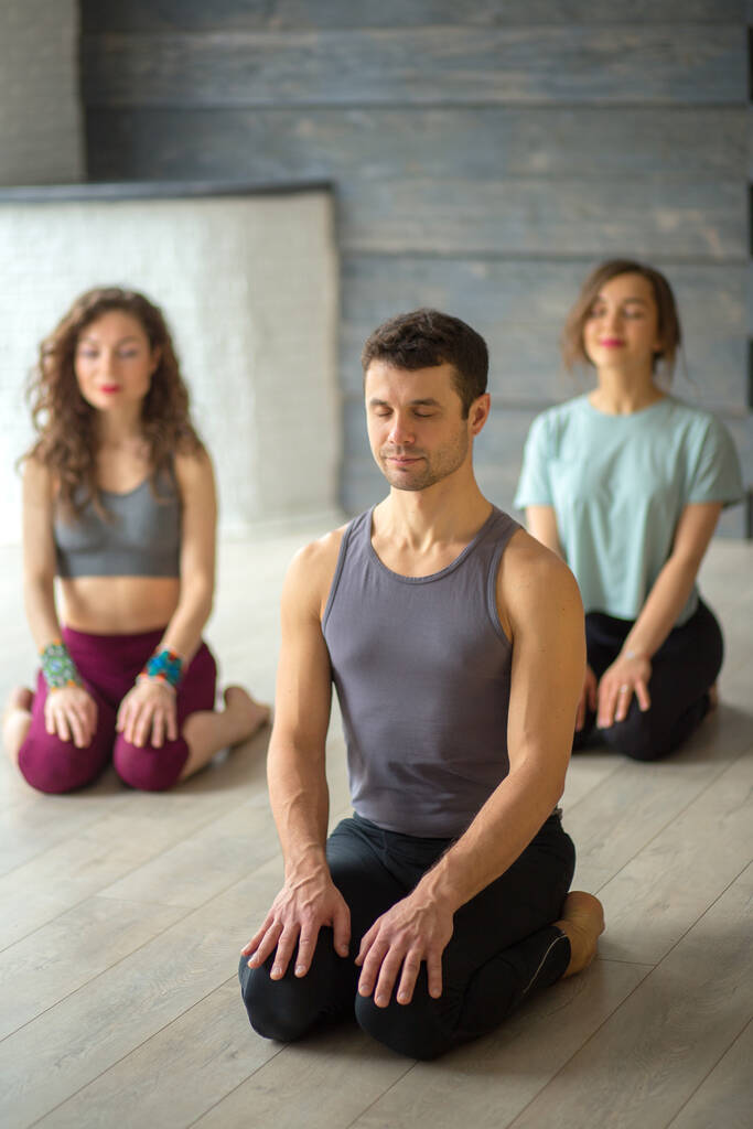 męski instruktor jogi biorąc lekcje jogi w studio fitness - Zdjęcie, obraz
