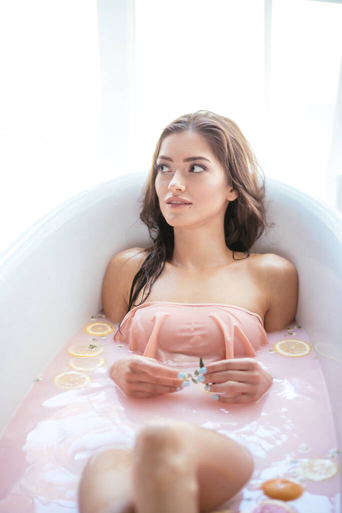 Nainen rentoutuu maitomaisessa kylvyssä kylpylässä. Hyvinvoinnin ja hyvinvoinnin käsite - Valokuva, kuva