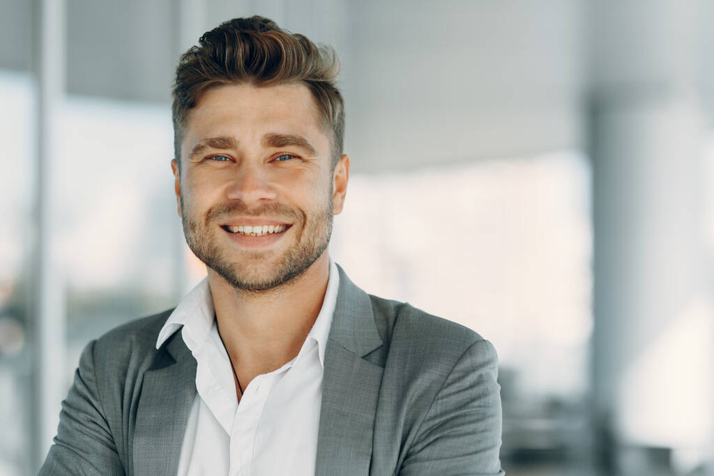 Profil portrait d'un homme d'affaires mature souriant et confiant vêtu d'un costume. Un jeune homme contre un mur gris. - Photo, image