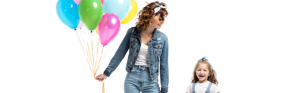 Mutter und Tochter im Jeans-Outfit mit bunten Luftballons, die Hände isoliert auf weißen, panoramischen Aufnahmen - Foto, Bild