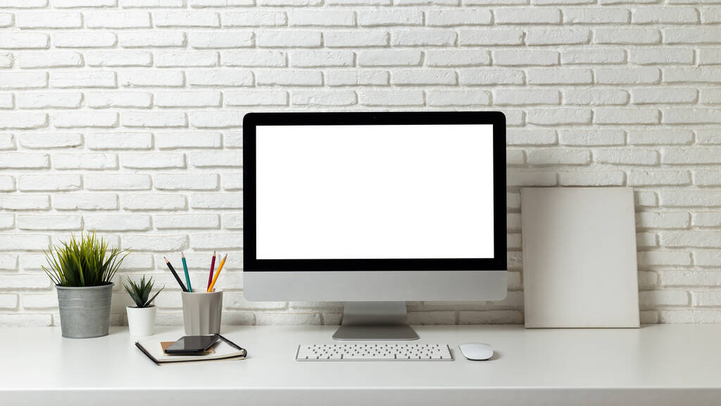Ordenador de pantalla en blanco burlón en un escritorio de madera. escritorio pantalla blanca vacía, con espacio de trabajo y suministros de oficina en la mesa - Foto, Imagen
