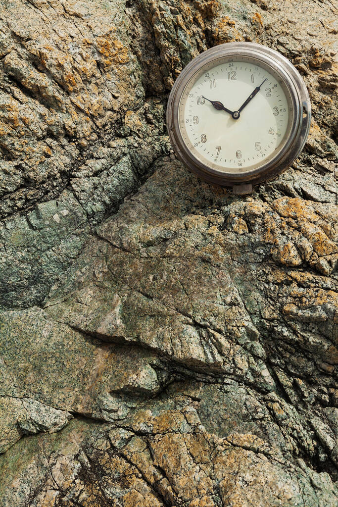 El viejo reloj redondo del barco en una roca, el verano en una orilla rocosa del mar. - Foto, Imagen