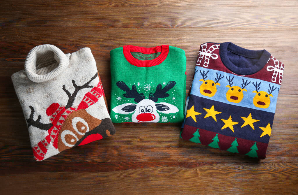Folded warm Christmas sweaters on wooden table, flat lay - Photo, Image