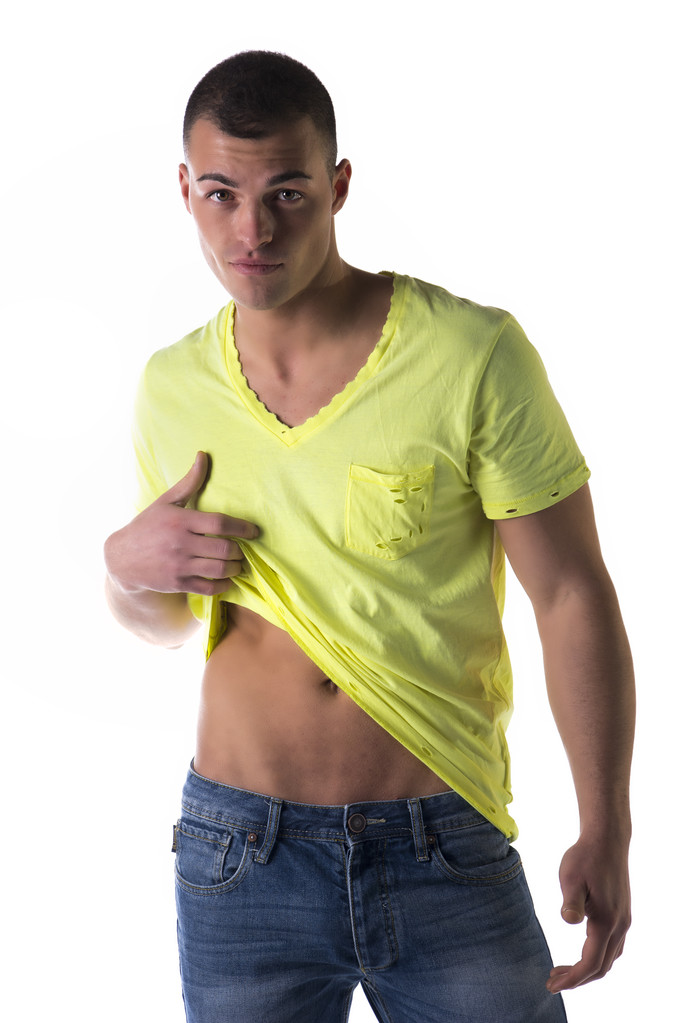 bel giovane uomo tirando su t-shirt per mostrare stomaco magro - Foto, immagini