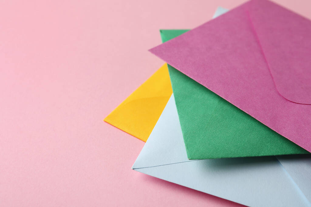 Enveloppes en papier coloré sur fond rose, gros plan. Espace pour le texte - Photo, image