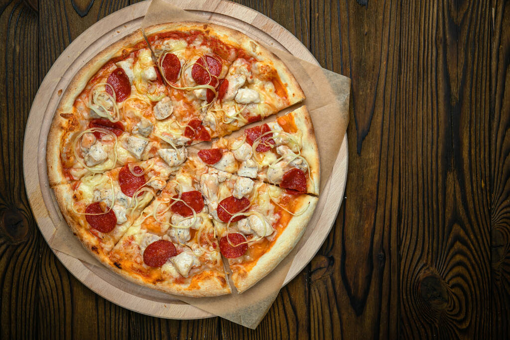 Pizza, op voorraad. op een bruine houten tafel. - Foto, afbeelding