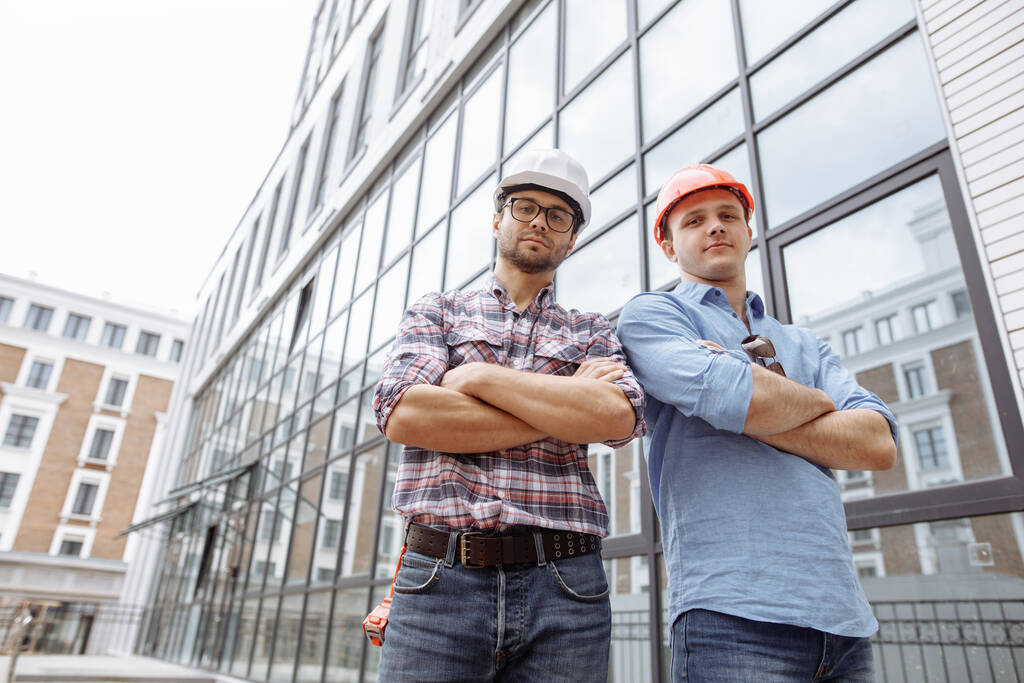 mahtava rakentajat seisoo ristissä kädet edessä toimistorakennus - Valokuva, kuva