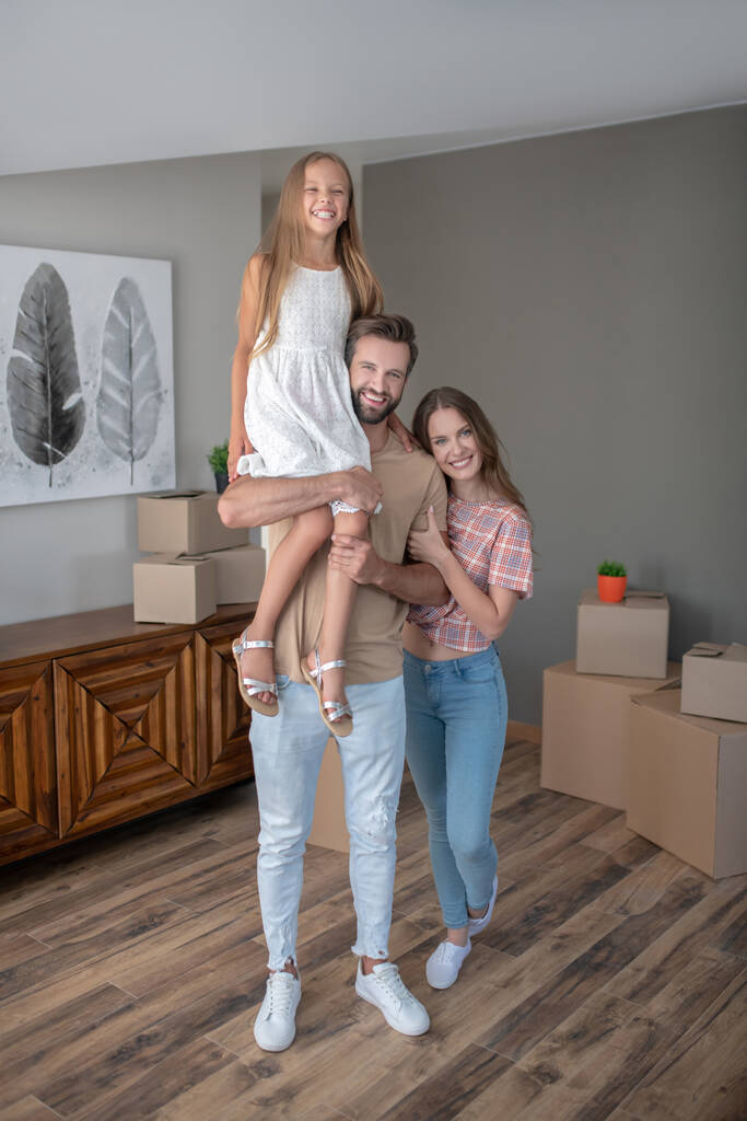 Eltern und Tochter verbringen Zeit gemeinsam im neuen Zuhause - Foto, Bild